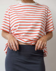 Person wearing a red and white t-striped shirt with a plain background