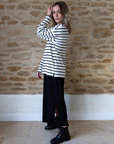 breton top worn over a black midi dress