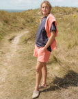 Woman standing on a grassy path with a scenic background