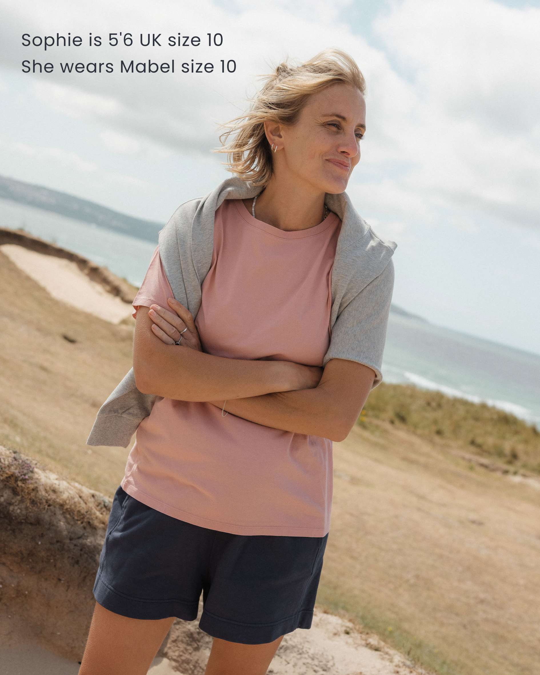 Woman standing outdoors with text about clothing size and brand