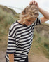 Woman wearing a black and white striped shirt outdoors with a natural background